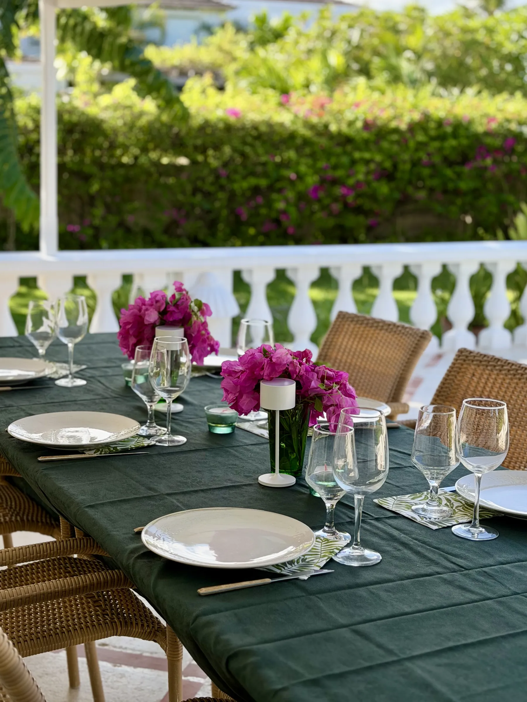 The dinner table on the porch, with bougainvillea and wine glasses