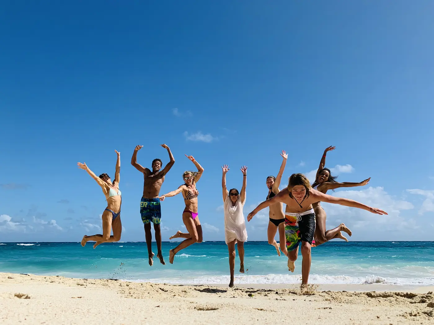 Friends and family jumping in the air on the beach