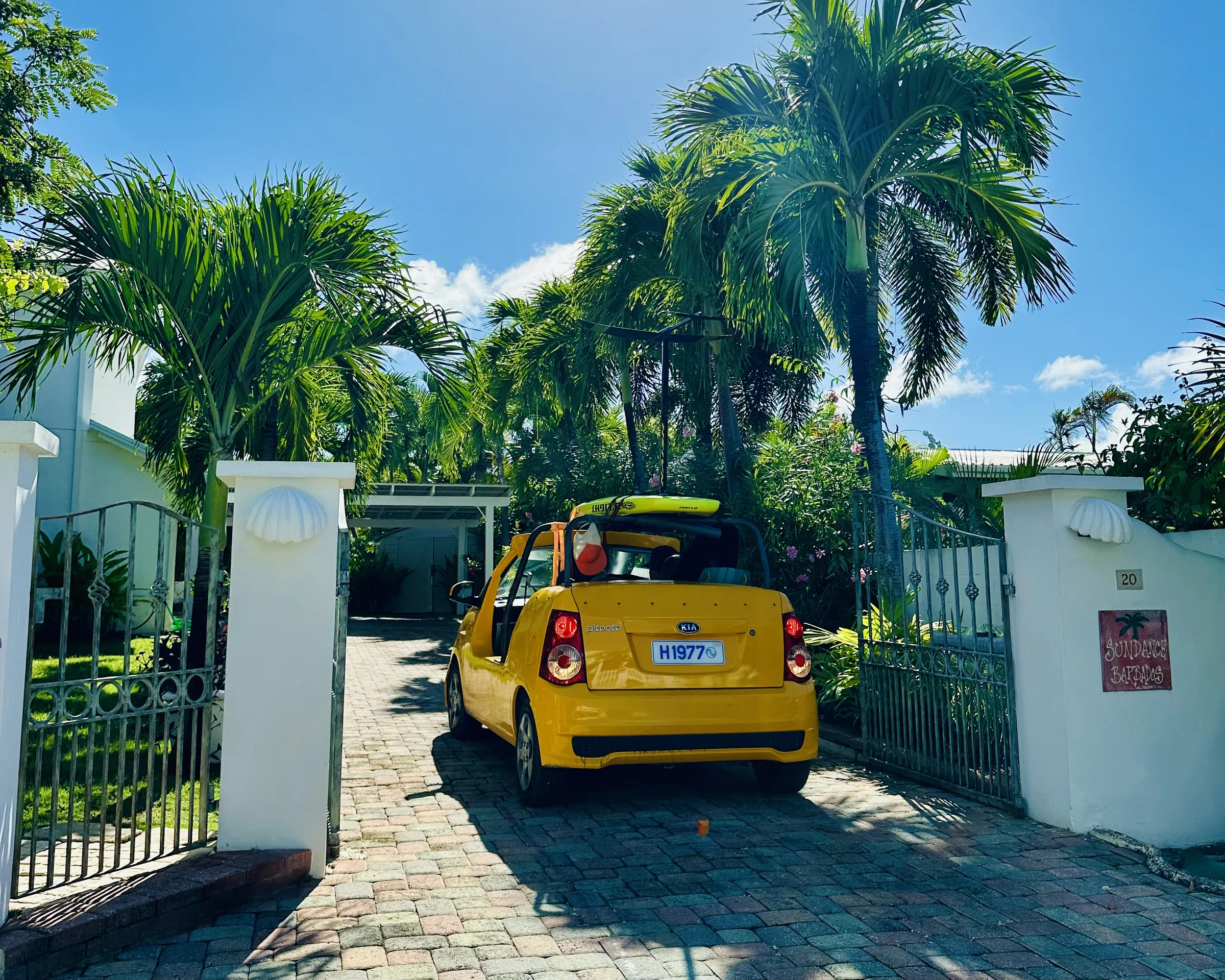 The yellow beach car at the gate of Sundance, under the palms